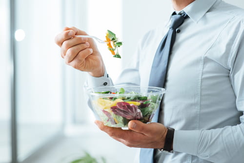 Home dinant directament d'un recipient transparent